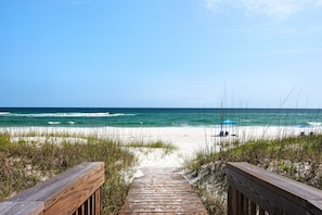 Ein hölzerner Weg führt zu einem Strand mit Blick auf den Ozean.