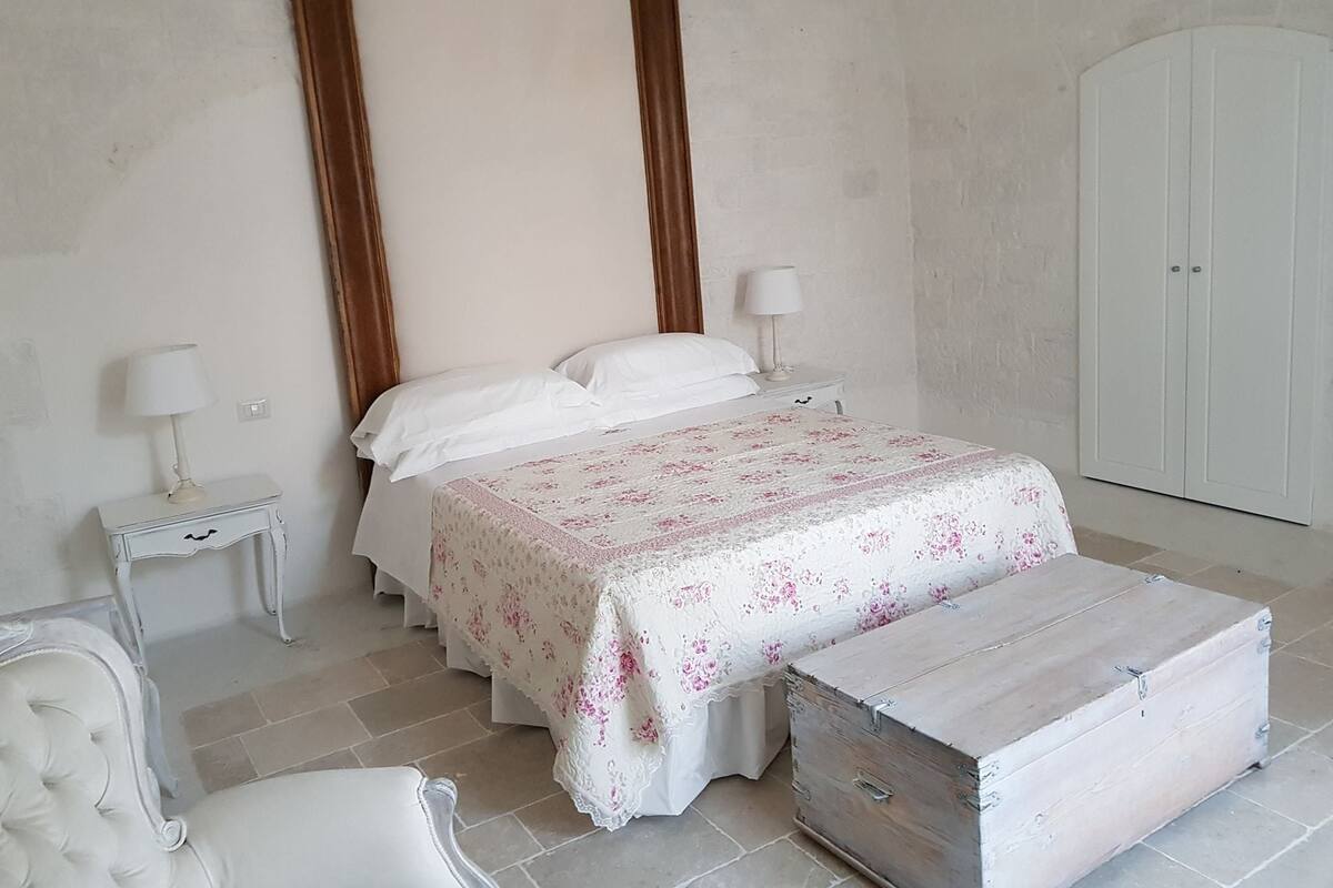 Une chambre à coucher comprenant un lit, deux tables de chevet, une commode et une armoire.