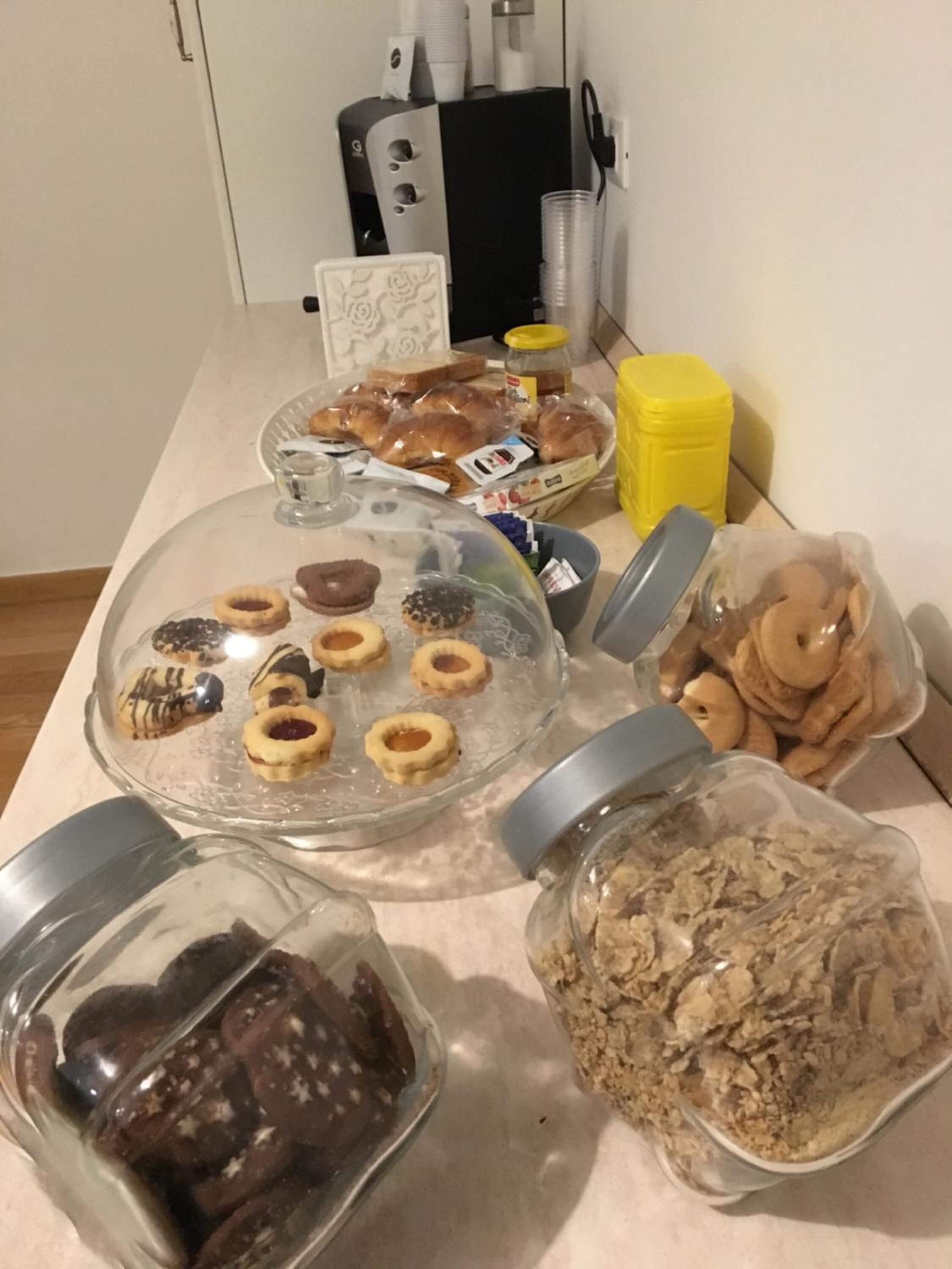 A kitchen counter with various food items including pastries, cookies, and jars of ingredients.