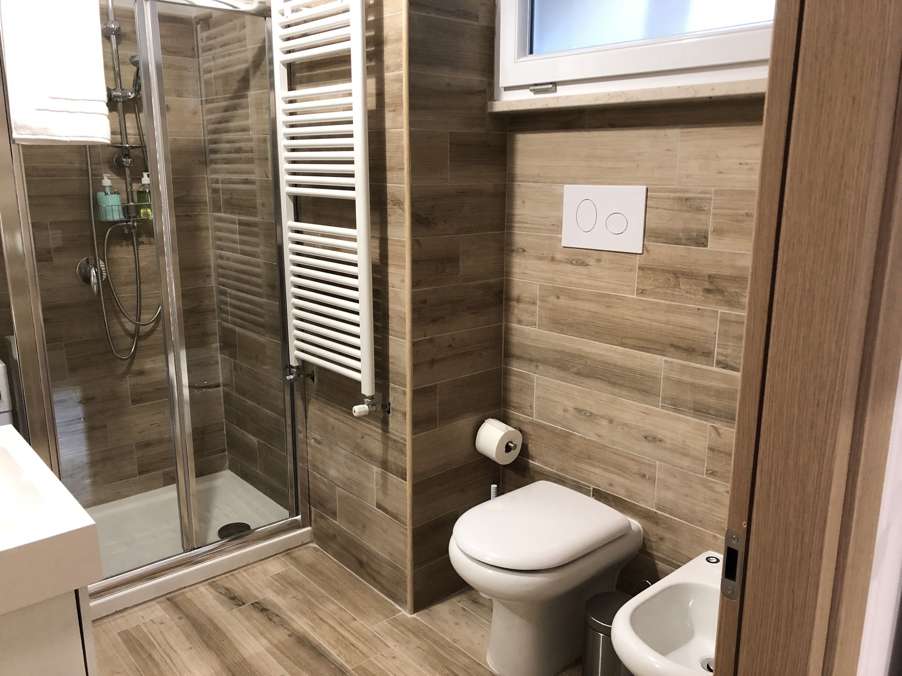 Un baño moderno con cabina de ducha de vidrio, inodoro y bidé.