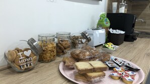 A kitchen counter with jars of cookies, a toaster, and a plate of bread and yogurt. - B&B Arco dolce Arco (Benevento)