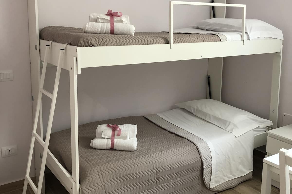 Eenvoudige vierpersoonskamer, privébadkamer (exterior) | Een bureau, een strijkplank/strijkijzer, babybedden, extra bedden