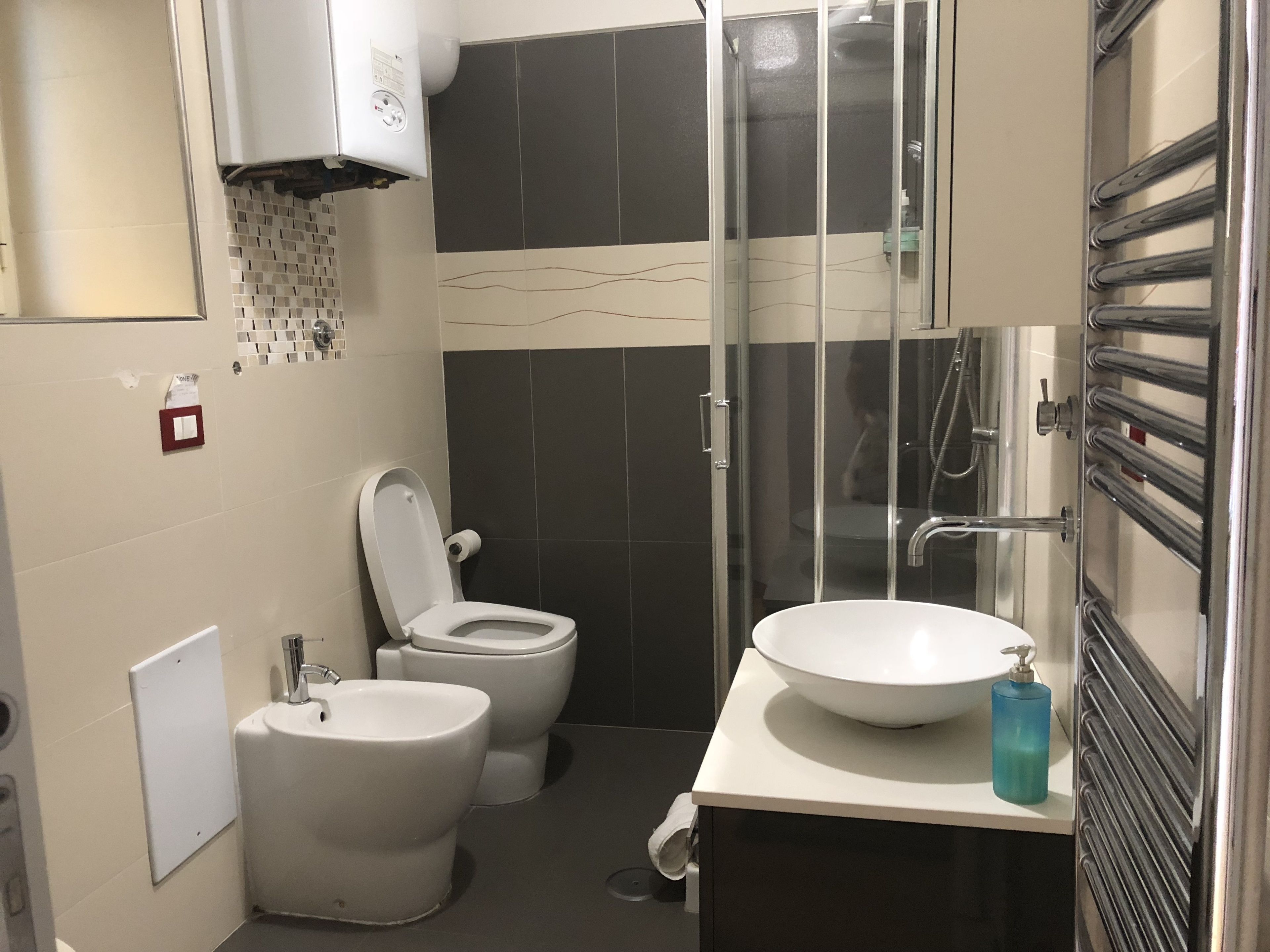 A modern bathroom with a toilet, bidet, and a large sink.