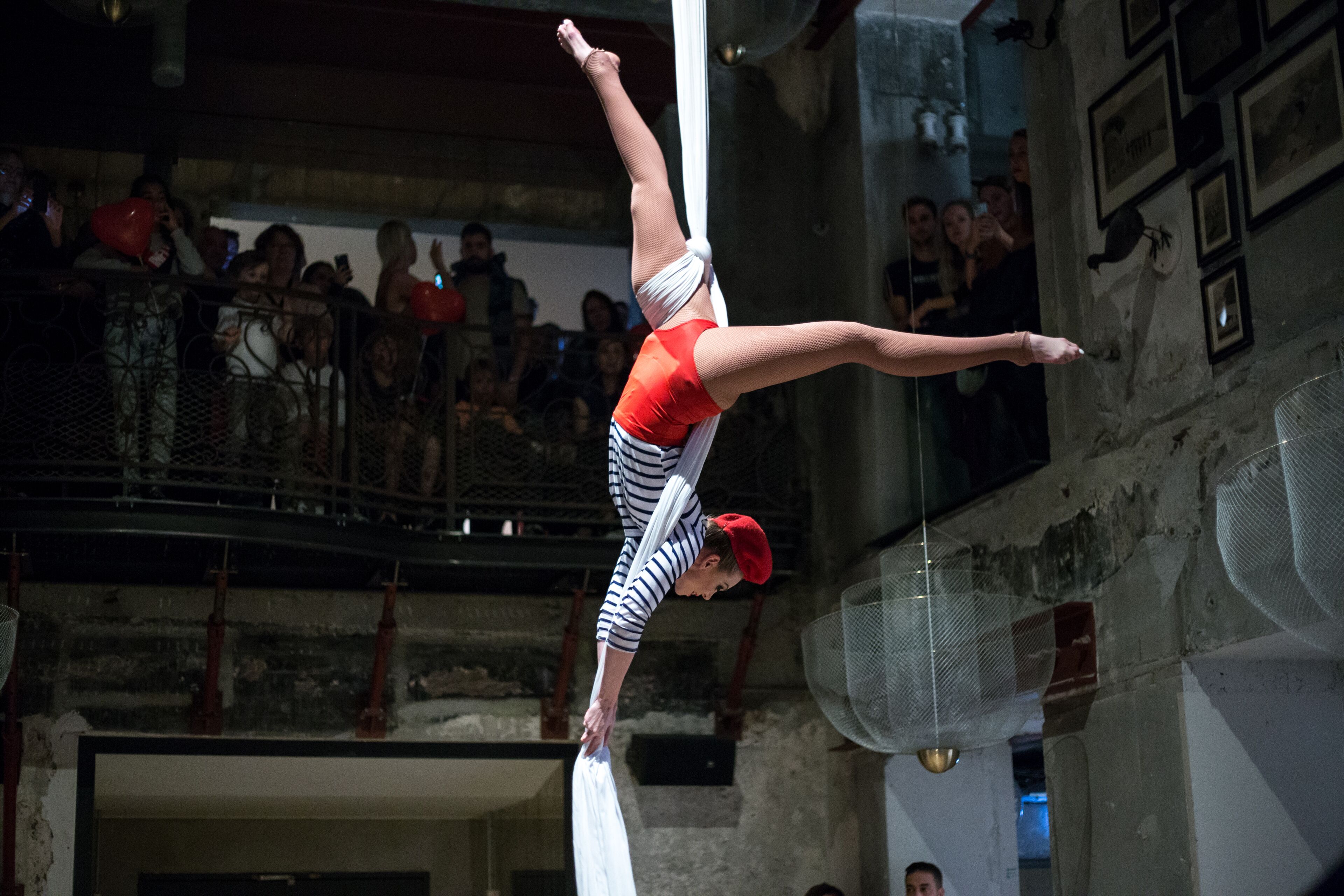 A person performing an aerial act on a white fabric.