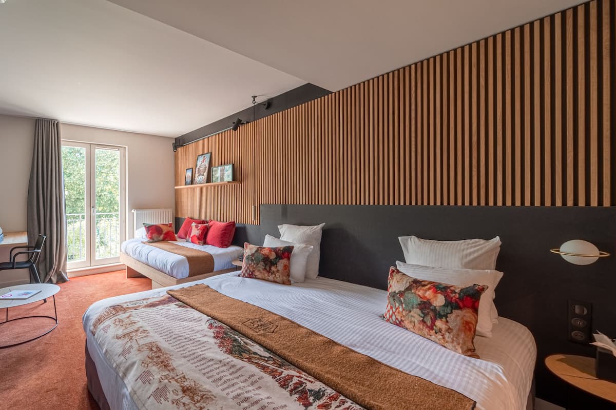 Une chambre d’hôtel avec deux lits, une grande fenêtre, un balcon et un design moderne.