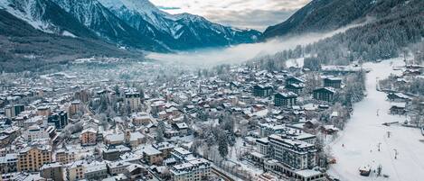 A snow-covered town with buildings and mountains in the background.