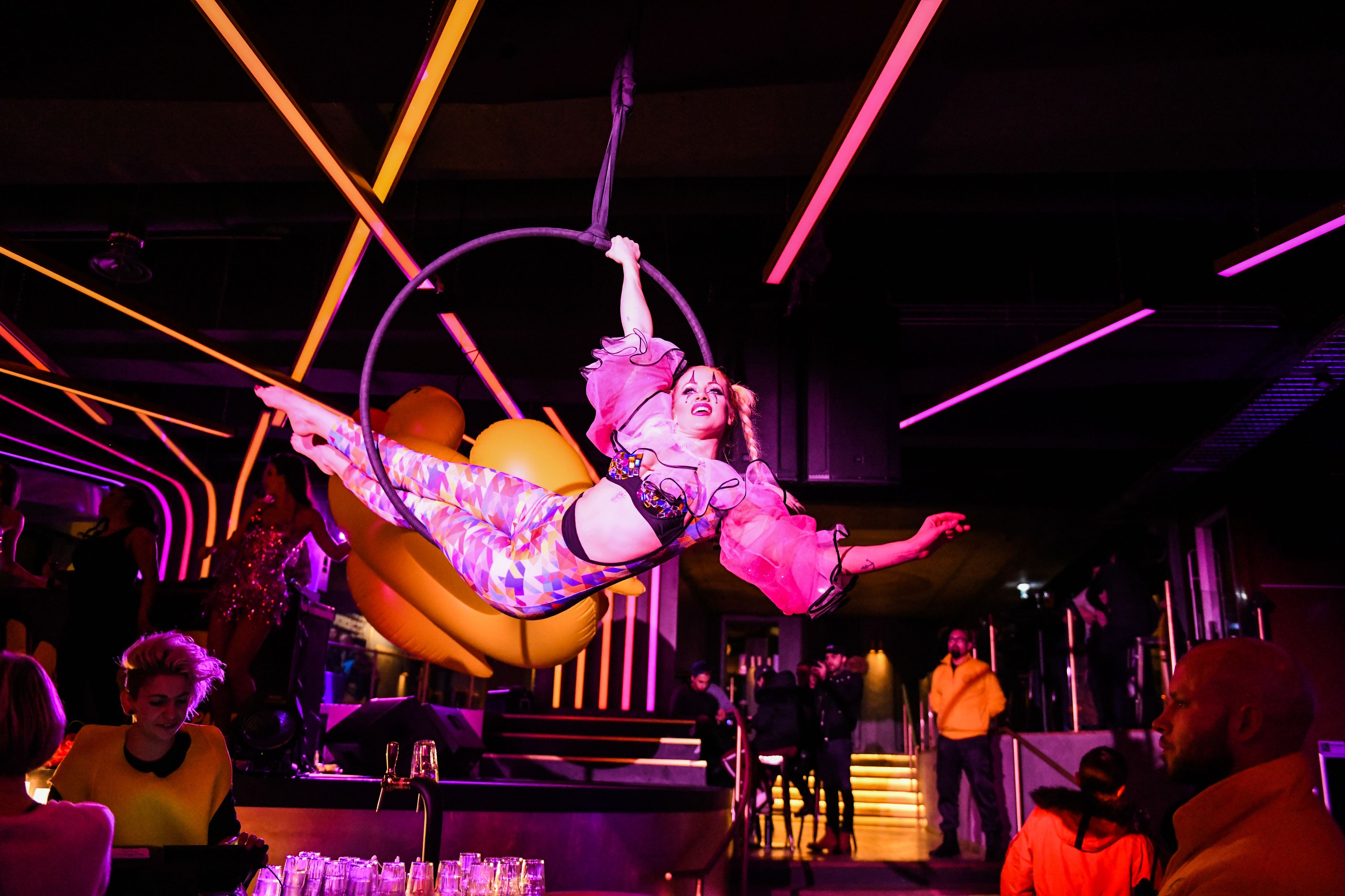 A performer in a colorful costume performing an aerial act.