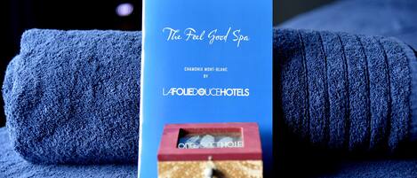 A blue booklet titled "The Feel Good Spa" by Chamonix Mont-Blanc, L'AFOLIEDOUCHEHOTELS, with a small image of a massage chair.