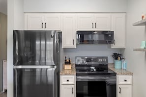 Enjoy cooking in this well-equipped kitchen with a refrigerator, microwave, and stove.