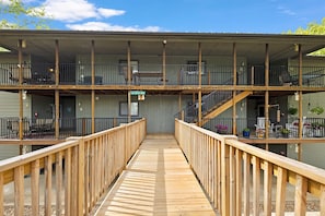 Stunning multi-story building with a central deck and covered entrance, featuring a simple design and balconies on each floor.