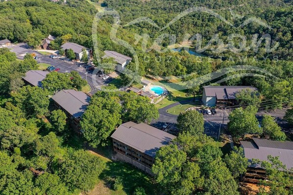 Residential area with unique homes, lush greenery, and a central swimming pool.