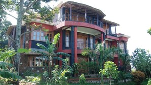 A multi-story house with a balcony, surrounded by lush greenery. - Dawilderness Holiday Homes (Kampala)