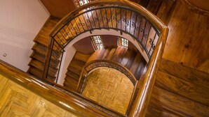 A wooden staircase with a curved design and metal railings. - Dawilderness Holiday Homes (Kampala)