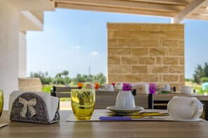 A table set with a teapot, cup, saucer, and a wicker basket with a bow. - Tenuta Libò (Alezio)