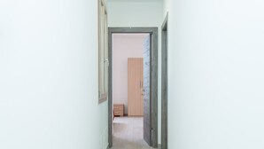 A narrow hallway with a wooden wardrobe and a door leading to another room. - Tenuta Libò (Alezio)