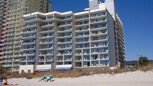 A multi-story hotel with balconies, located near a beach. - Seaside Serenity: Stunning 2-Bedroom Beachfront Condo with Unmatched Ocean Views (Myrtle Beach)