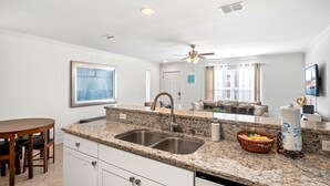 A modern kitchen with granite countertops, stainless steel sinks, and a ceiling fan. - 2min Walk to Private Beach! 3BR Gorgeous Townhome! (Miramar Beach)