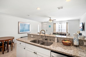 Enjoy meals in this kitchen with a dining table and chairs, overlooking the city through large windows.