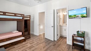 A bedroom with a bunk bed, a ceiling fan, a TV on the wall, and a view of the beach through the open door. - 2min Walk to Private Beach! 3BR Gorgeous Townhome! (Miramar Beach)