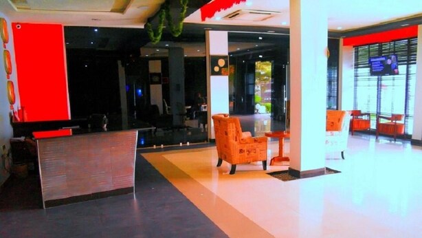 Un vestíbulo moderno con mostrador de recepción, zona de estar y un amplio ventanal.