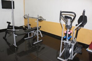 A gym with a bench press, a squat rack, and a stair climber. - Park Hotels (Port Harcourt)