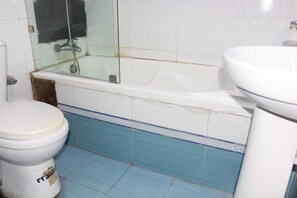 A bathroom with a toilet, a glass-enclosed bathtub, and a sink. - Park Hotels (Port Harcourt)