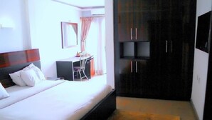 Un dormitorio con cama, escritorio y armario.