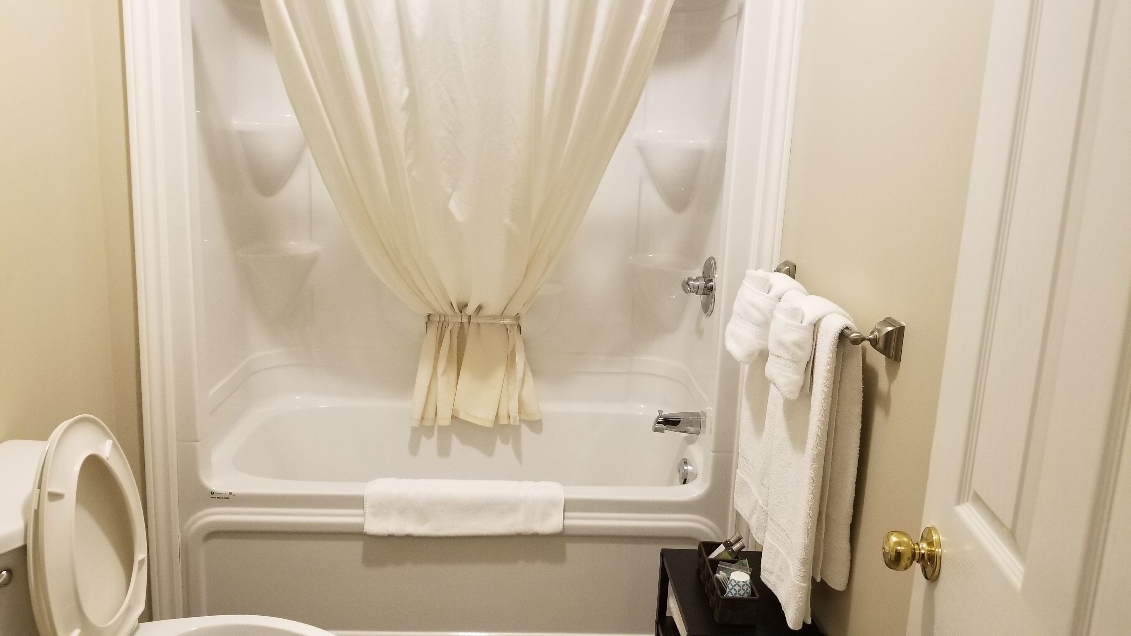 Un baño con bañera, inodoro y perchero para toallas.