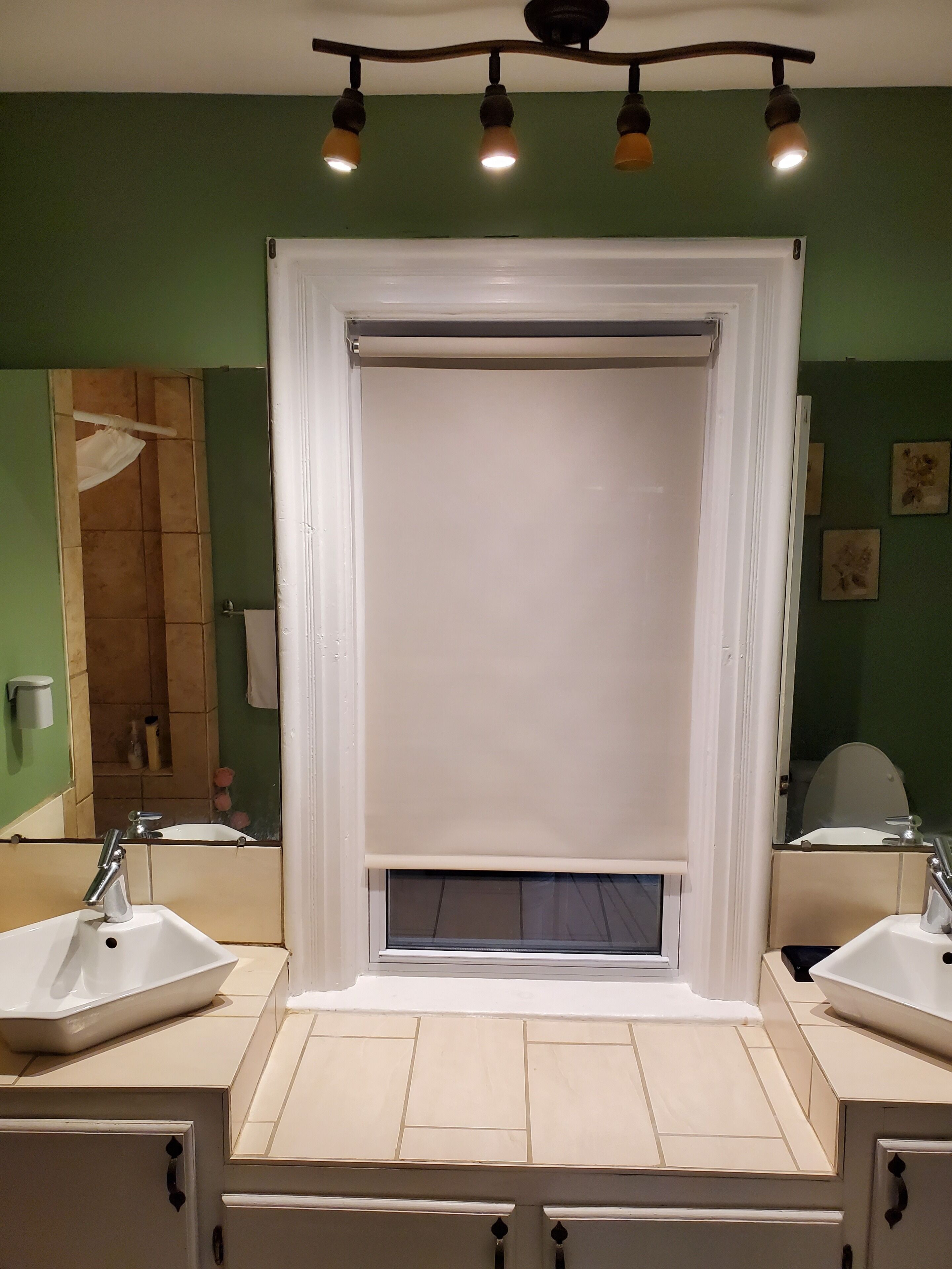 A bathroom with two sinks, a shower curtain, and a mirror.