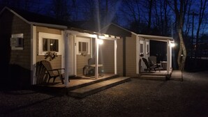 A small, single-story building with a porch area. There are two chairs and a table on the porch. The building has a number '2' on the door. - Rothesay Motel (Rothesay)