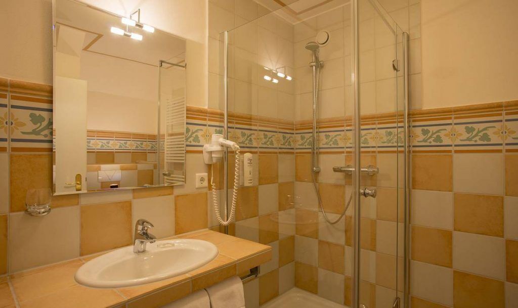 Ein Badezimmer mit Waschbecken, Spiegel und Dusche.