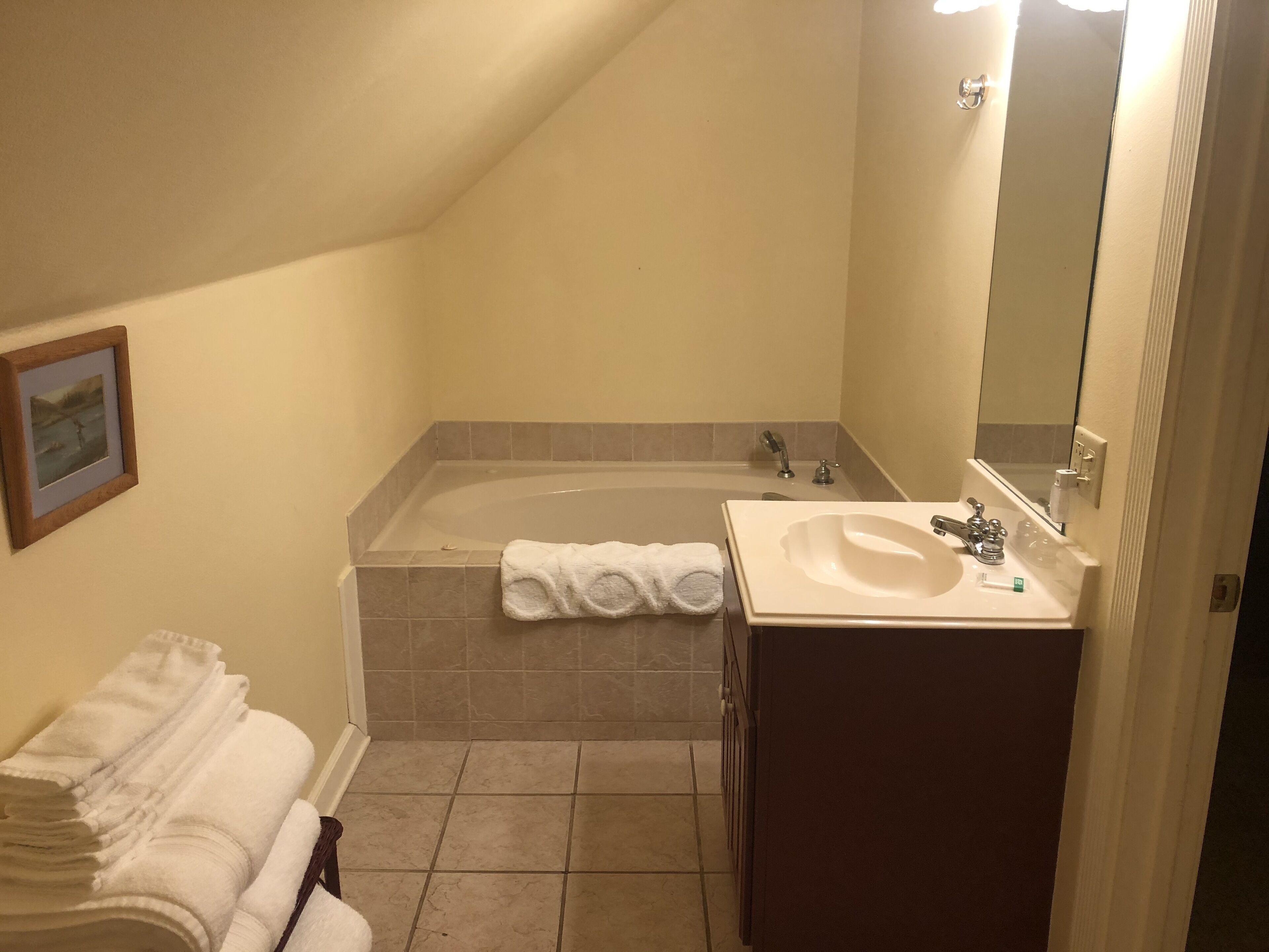 Un baño con bañera, lavamanos y espejo.