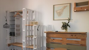 Une pièce comprenant un bureau en bois, un porte-manteau suspendu et une étagère.
