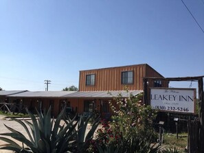 Un bâtiment à deux étages, sur lequel on peut voir une enseigne indiquant « Leakey Inn », avec un design d’époque et un numéro de téléphone.