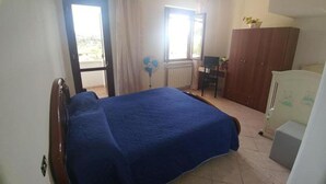 A bedroom with a bed, a desk, a wardrobe, and a radiator. - B&B Iafrate Daniele (Priverno)