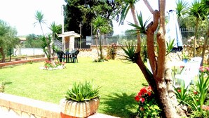 A well-maintained garden with a patio area, stone walls, and various plants. - B&B Iafrate Daniele (Priverno)
