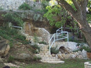 A stone staircase leading up to a building with a tree in the foreground. - Frio Springs Lodges (Leakey)