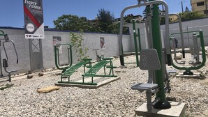 Équipement de gymnastique en plein air, comprenant des barres de traction et des bancs, avec une signalétique indiquant « Espace Fitness ».