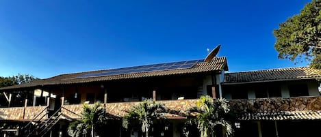 Ein Gebäude mit geneigtem Dach, Solaranlagen und einer Steinaußenwand.