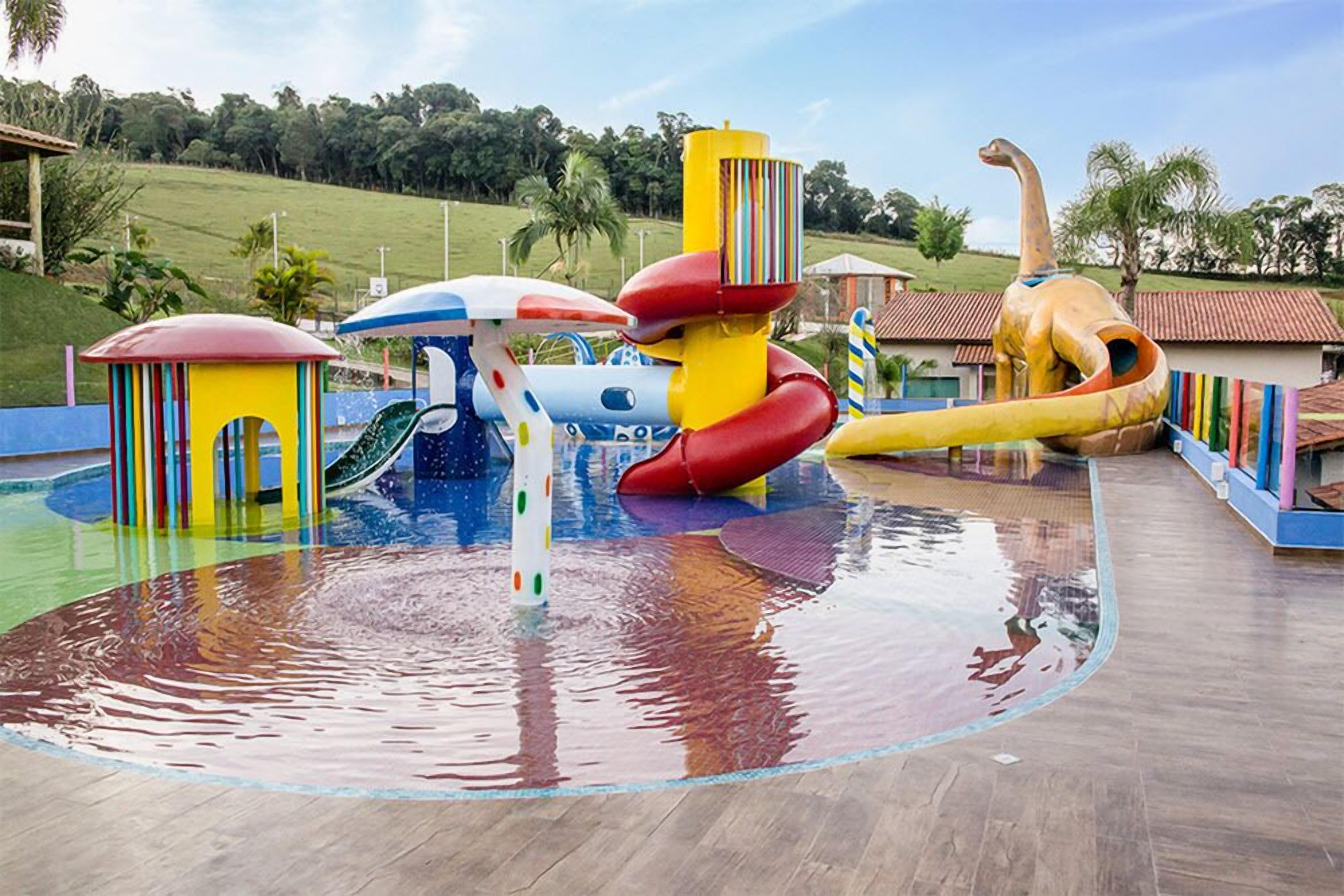 A water park with various colorful play structures, including slides and a water slide.