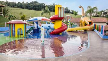A water park with various colorful play structures, including slides and a water slide.