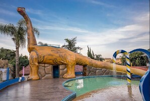Una piscina techada, una piscina al aire libre, sombrillas