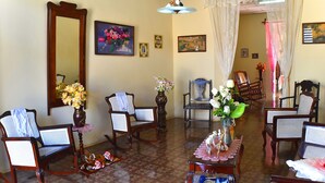 A traditional living room with wooden furniture, a large mirror, and floral decorations. - Hostal la Campiña (Remedios)