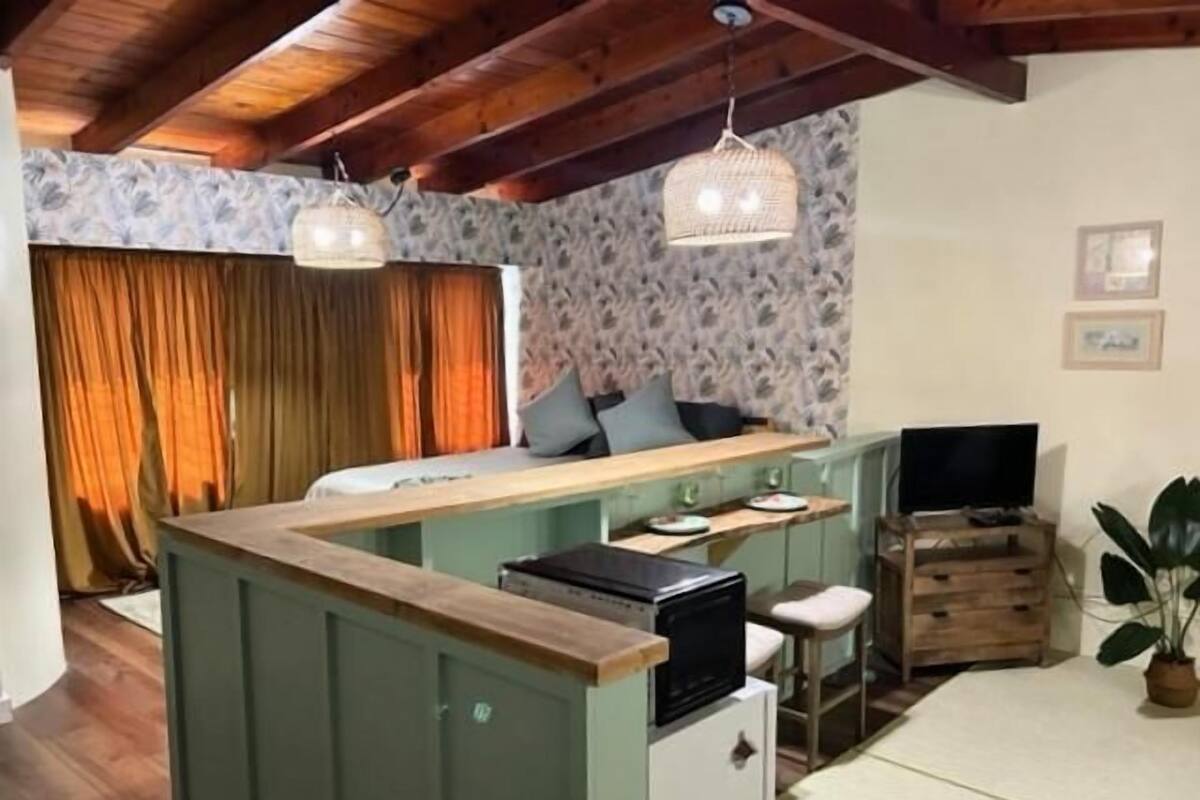 A compact living space with a kitchenette, a dining area, and a seating area.
