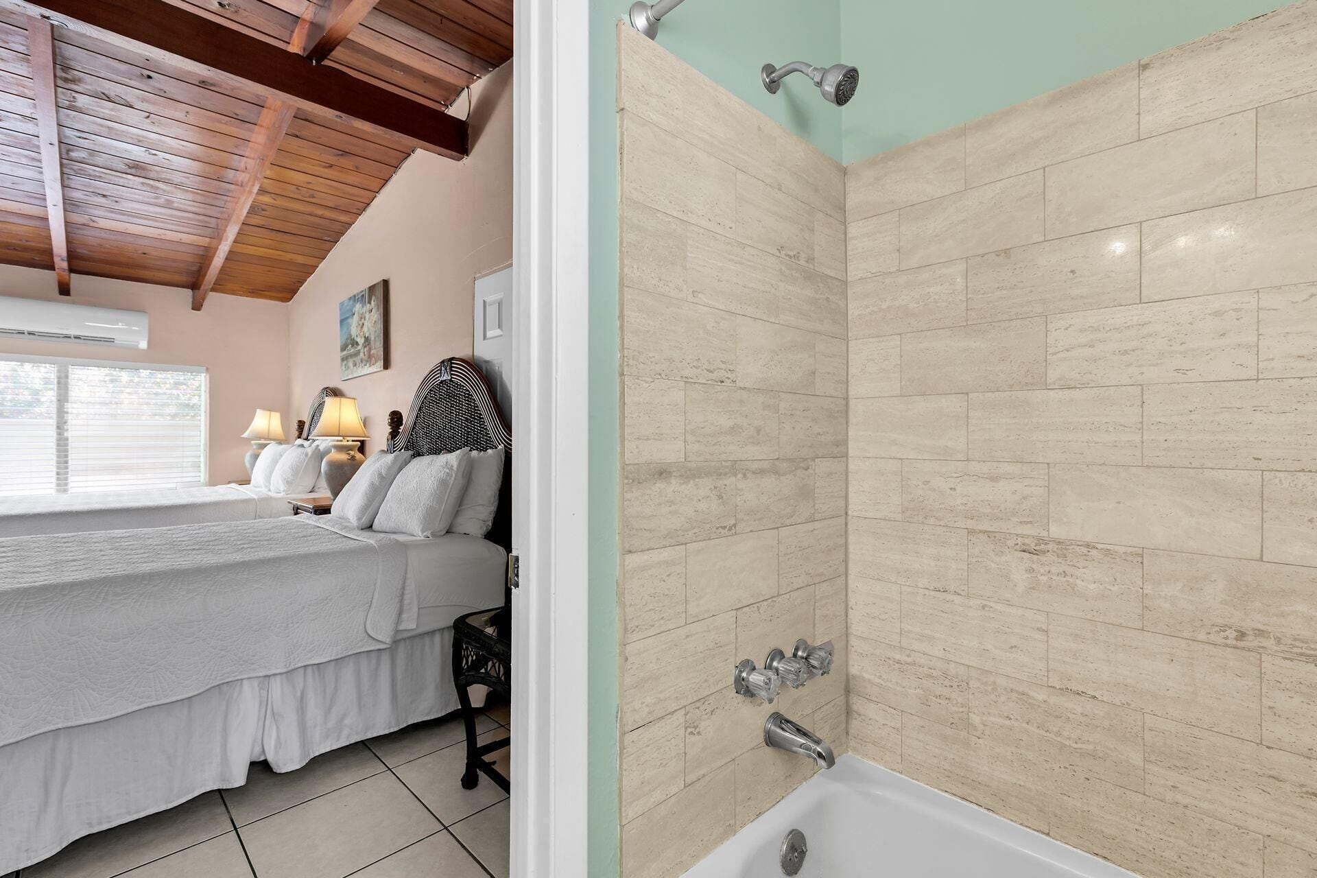 Un dormitorio con cama, lámparas de noche y ventana.