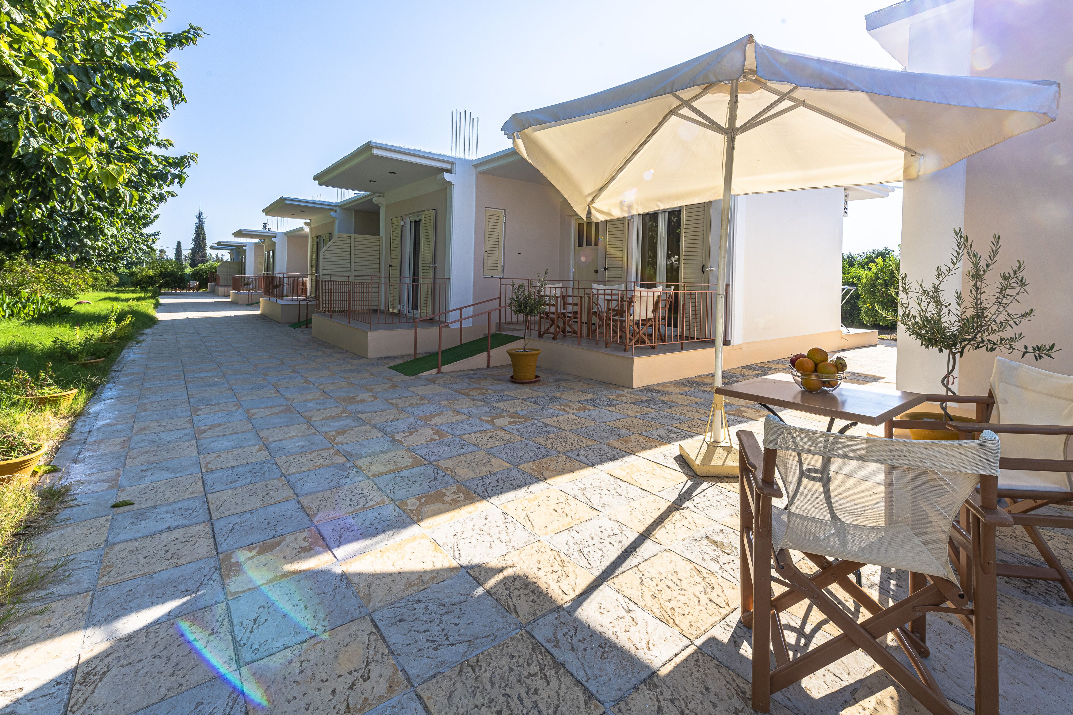 A courtyard with outdoor seating, a tiled floor, and a potted plant.
