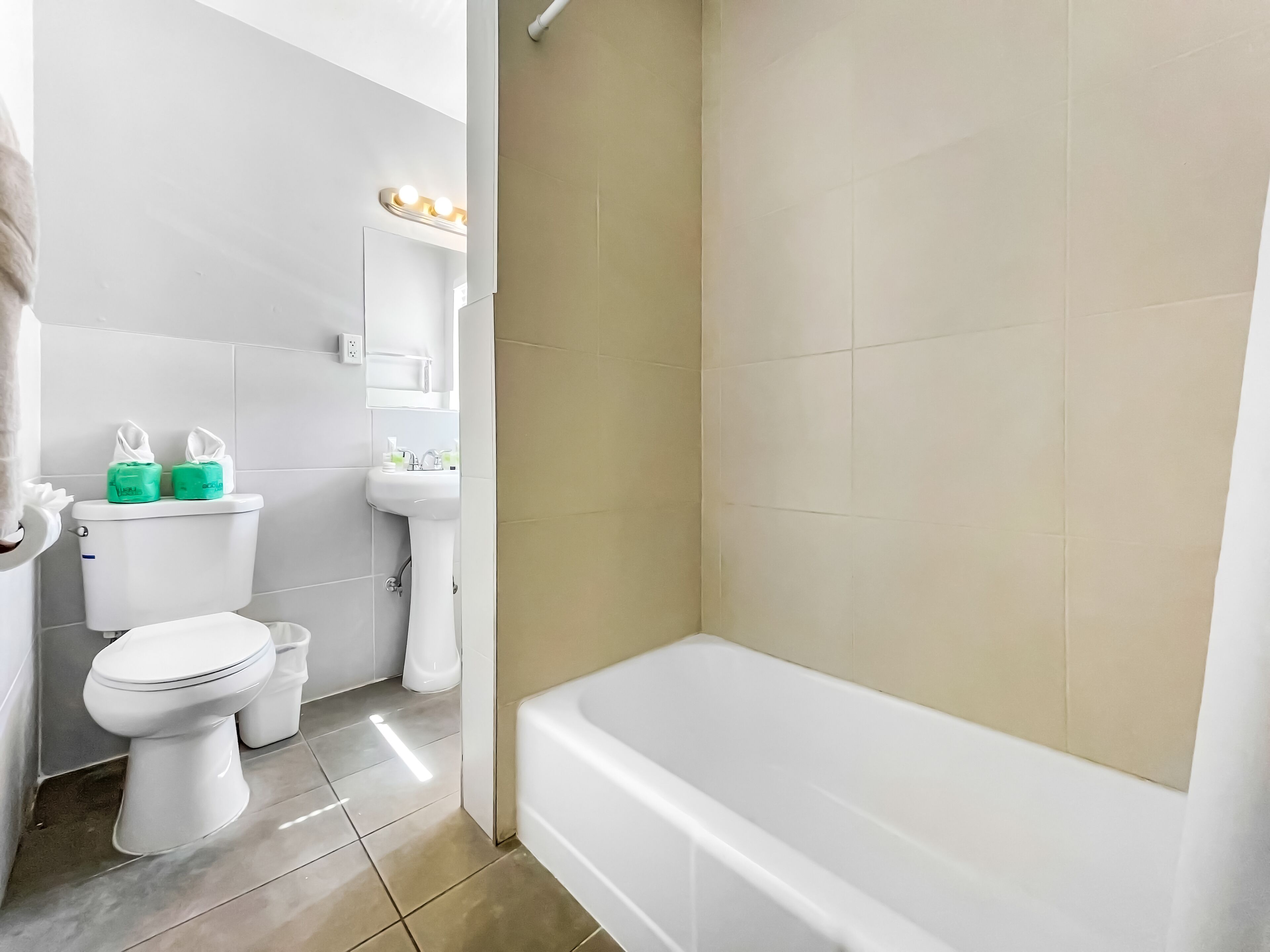 A bathroom with a toilet, sink, and bathtub.