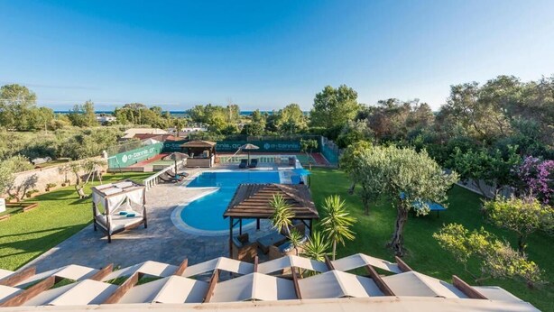 A pool area with a pergola, lounge chairs, and a view of the sea. - Villa Maxim with Private Pool & Tennis Court (Corfu)