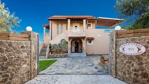 A Mediterranean-style villa with a stone facade, a tiled roof, and a welcoming entrance. - Villa Maxim with Private Pool & Tennis Court (Corfu)