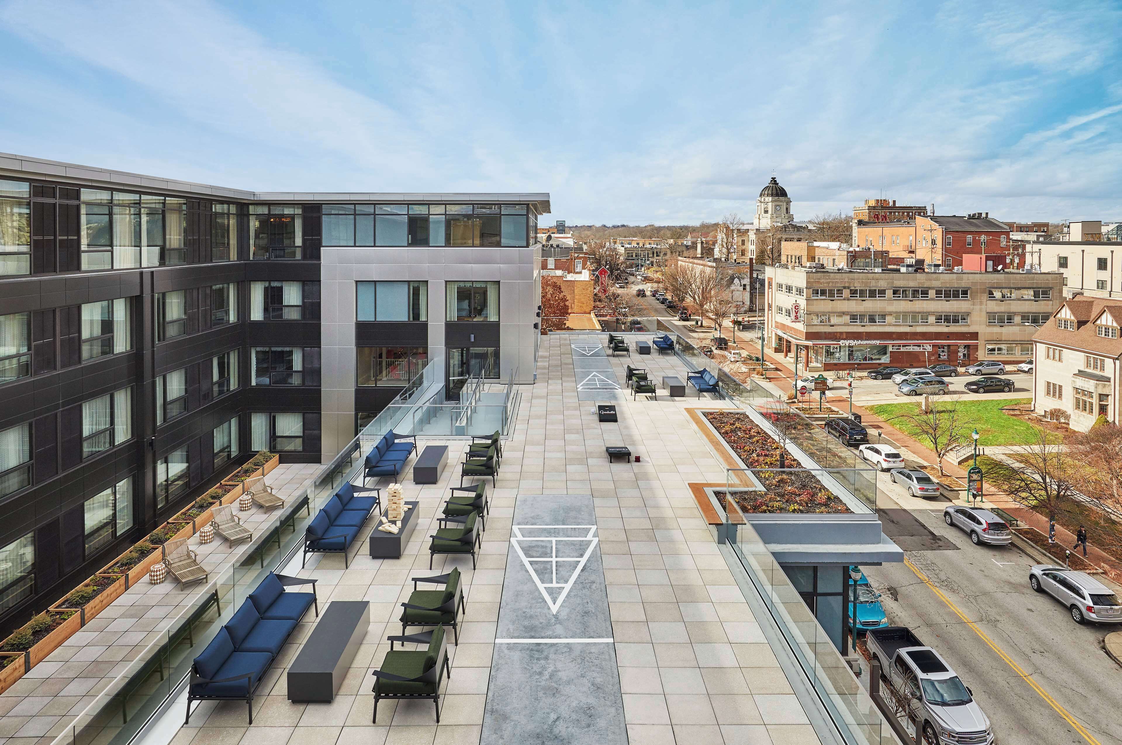 Terraza en la azotea con mobiliario exterior y vista panorámica de la ciudad.